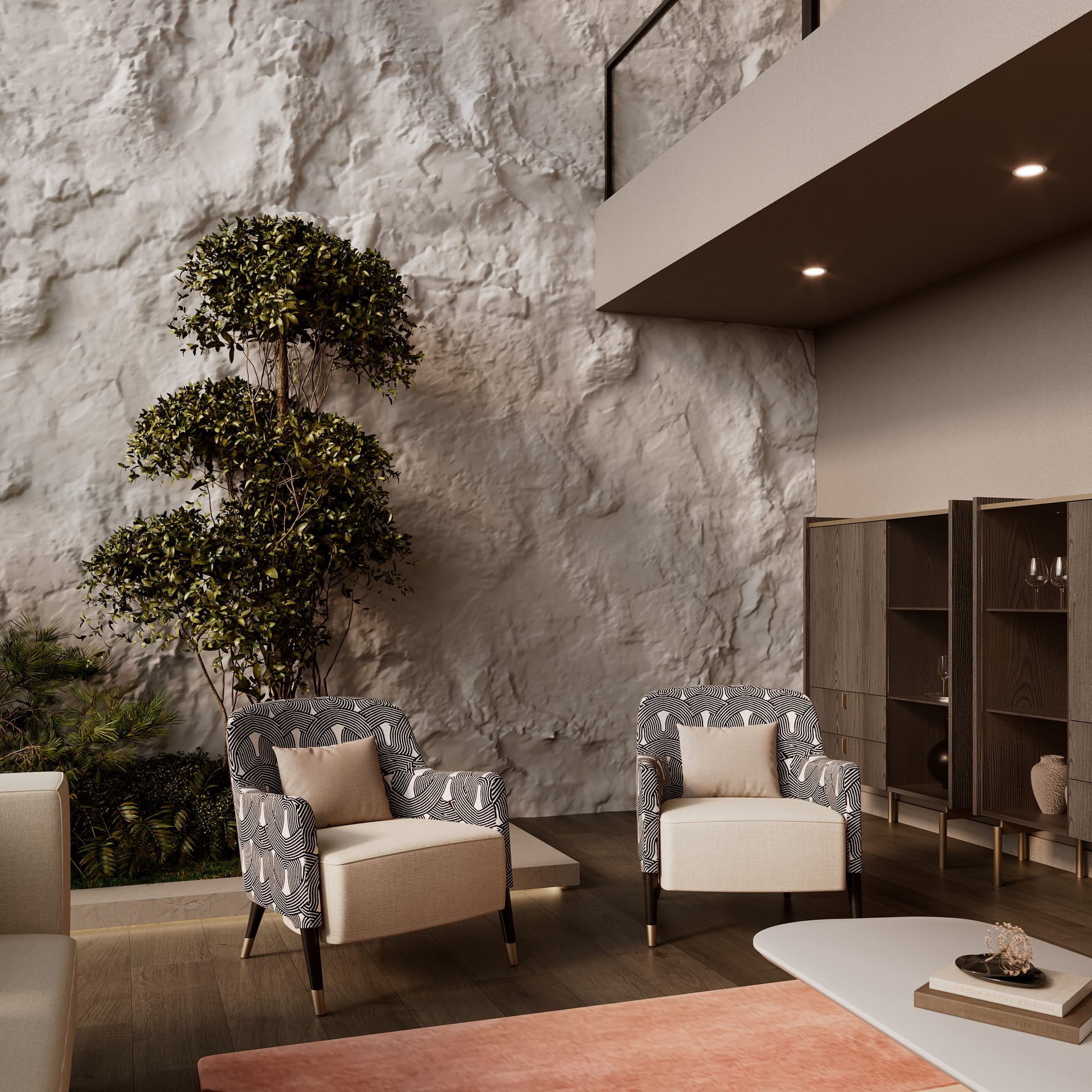 Rough white stone wall with clipped tree, two patterned armchairs with cream seats and dark wood cabinets
