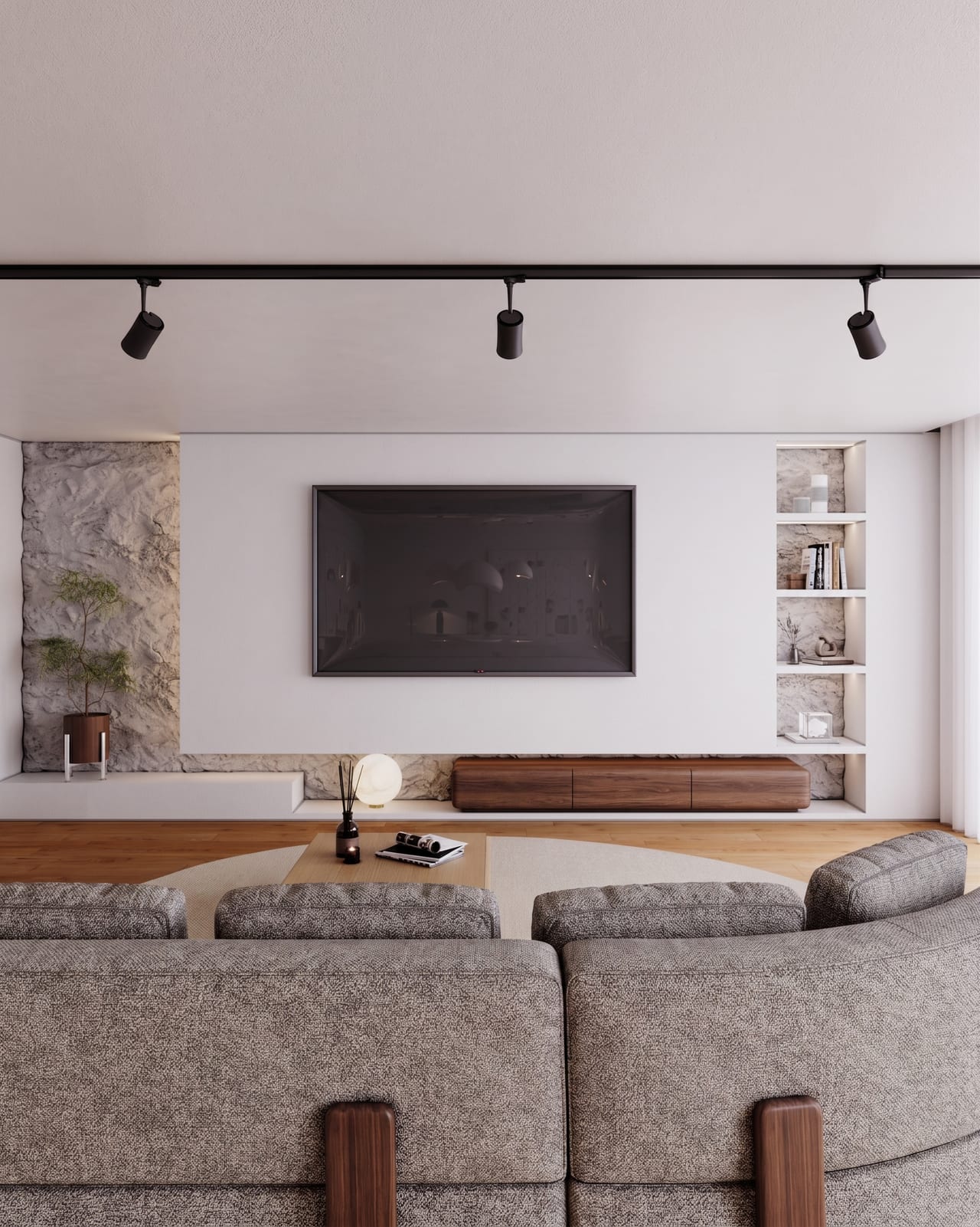 White and pale stone television wall with a wall-hung dark wood unit and a grey curved sofa in front