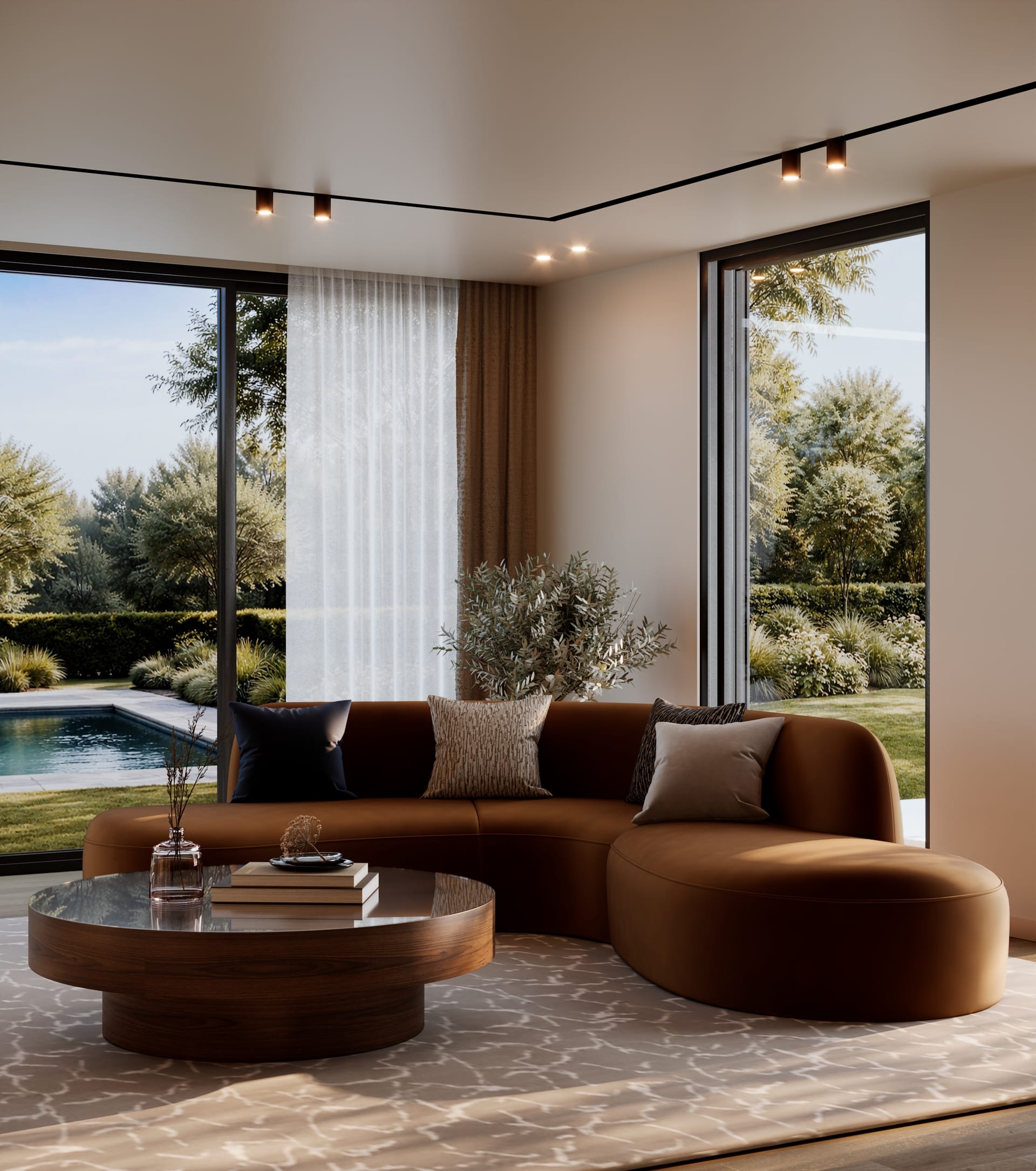 Curved sofa in caramel upholstery and a round dark wood table, with full-height glazing onto garden and pool