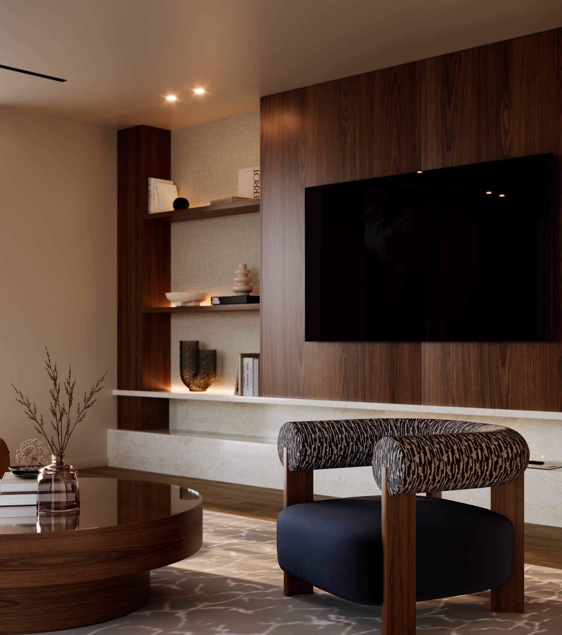 Dark blue armchair with patterned back facing the wood panel with television and lit display niches
