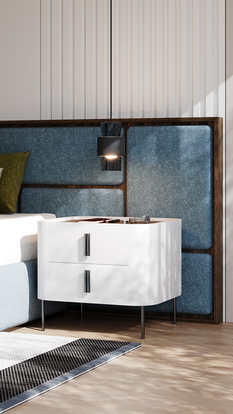 White bedside table with curved corners and metal legs, beside a blue headboard and black wall light